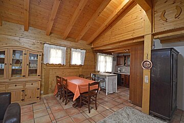 A wooden dining room with a table and chairs