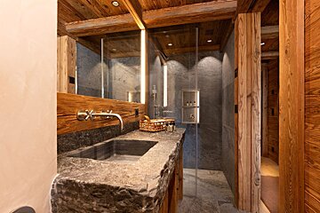 A bathroom with a sink and a walk in shower