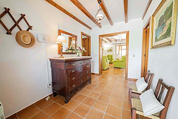 A hallway with a dresser and a picture on the wall