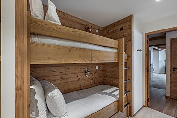 A bedroom with a painting on the wall above the bed