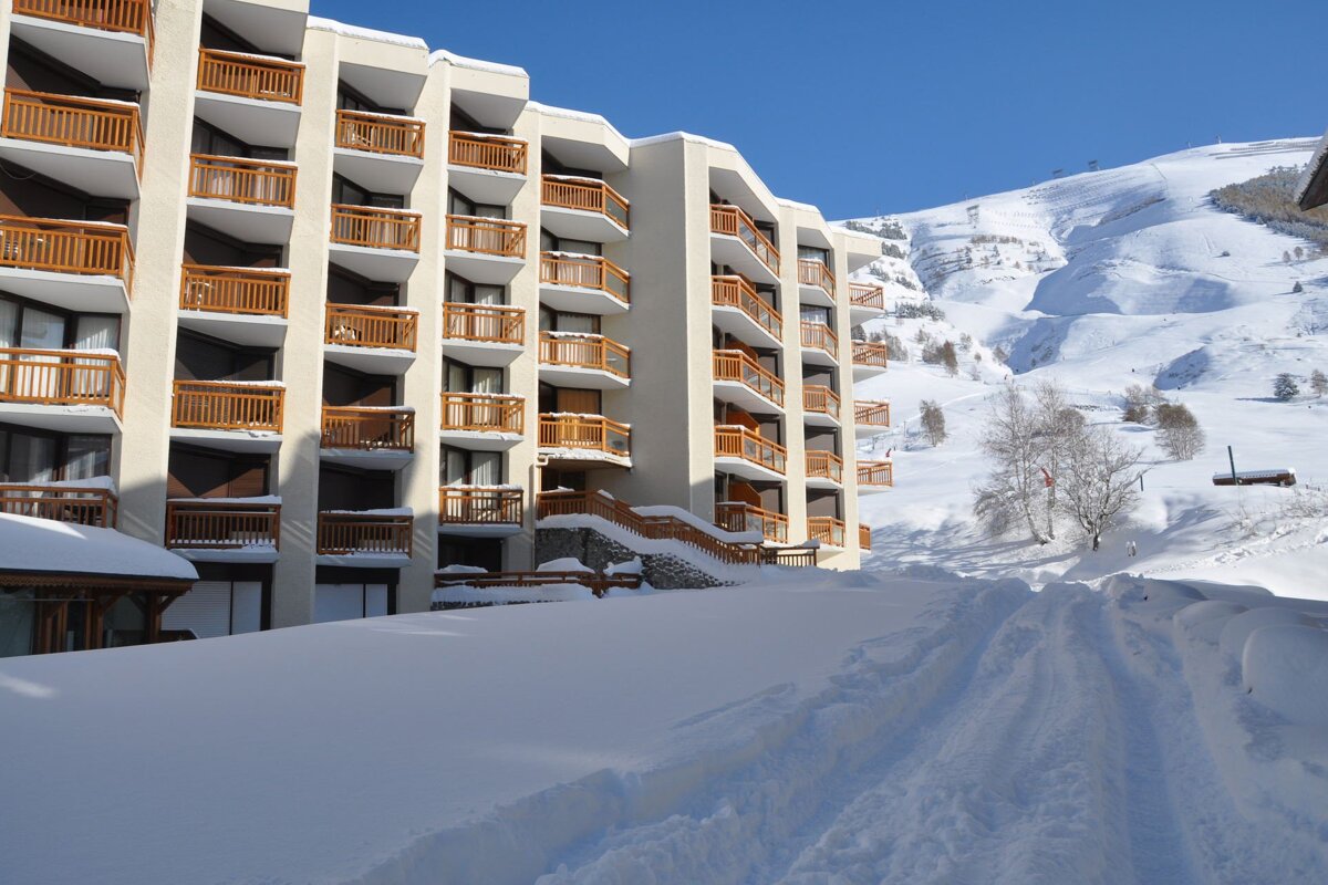 A building with a lot of balconies is covered in snow