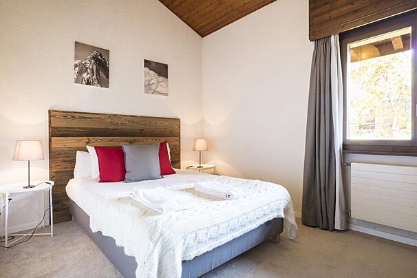 A bedroom with a bed and a wooden headboard