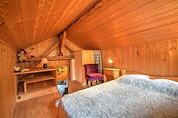 A bedroom with a bed and a purple chair