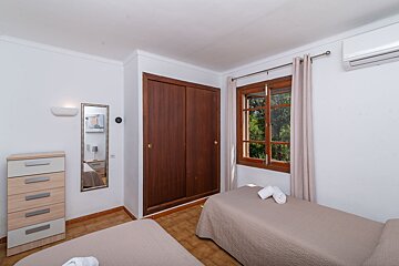 A bedroom with two beds and a dresser