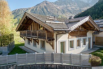 A house with a balcony and a mountain in the background
