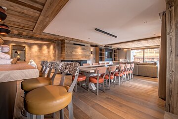 A dining room with a long table and chairs