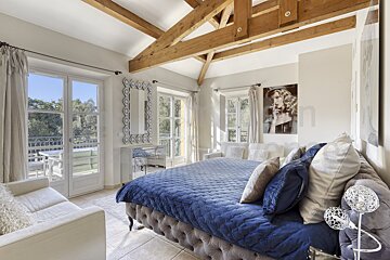 A bedroom with a large bed and a painting on the wall