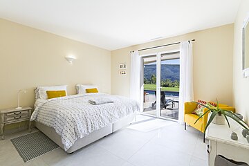 A bedroom with a large bed and a yellow chair