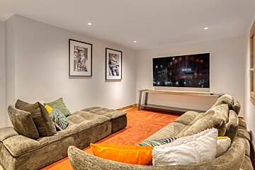 A living room with a large couch and a flat screen tv