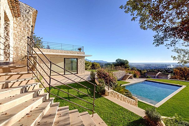 Stairs leading up to a house with a large swimming pool