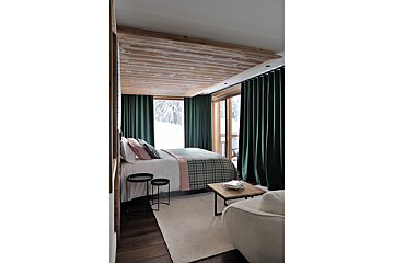 A bedroom with a large bed and green curtains