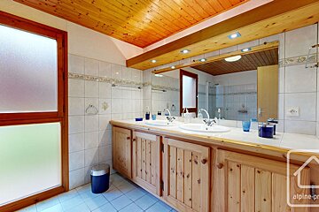 A bathroom with two sinks and a sign that says alpine-pr