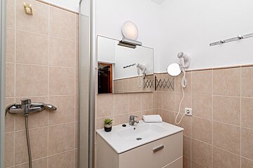 A bathroom with a sink a mirror and a hair dryer