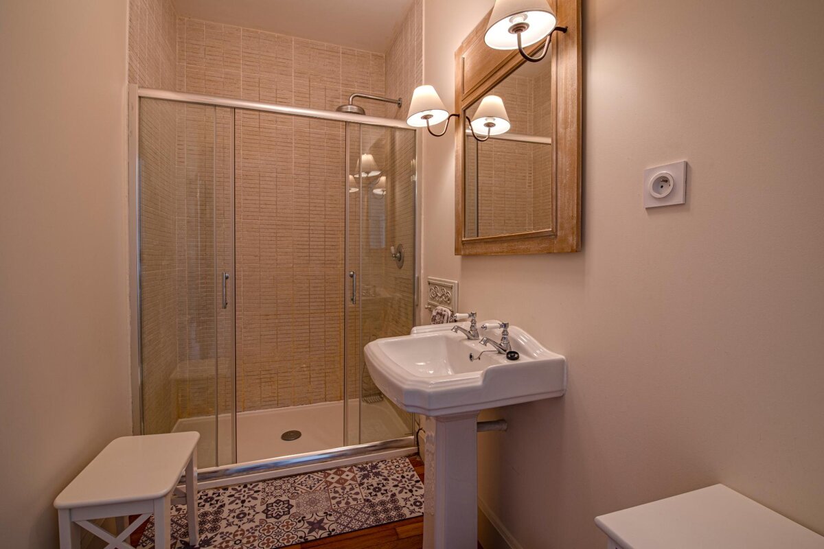 A bathroom with a sink and a walk in shower