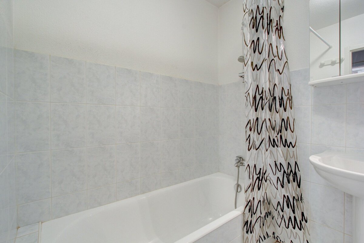 A bathroom with a bathtub and a shower curtain