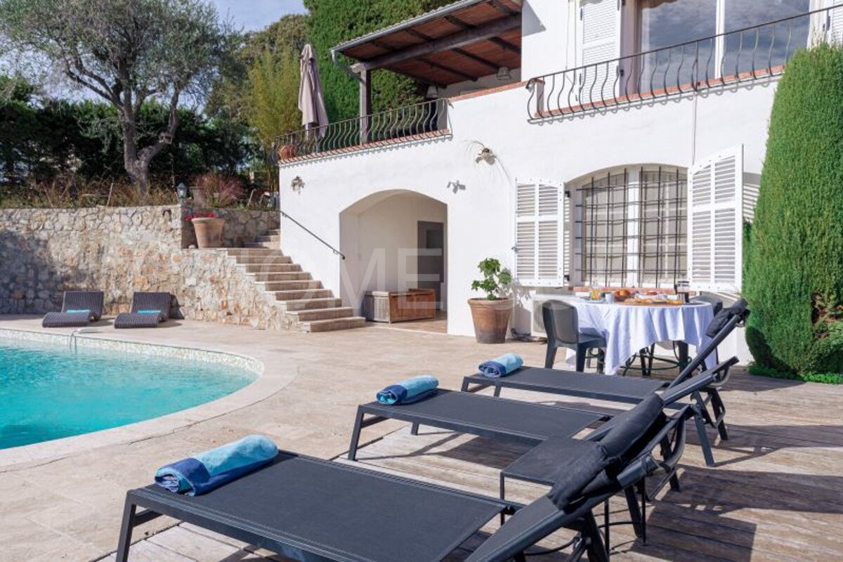 A large white house with a swimming pool in front of it