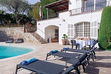 A large white house with a swimming pool in front of it