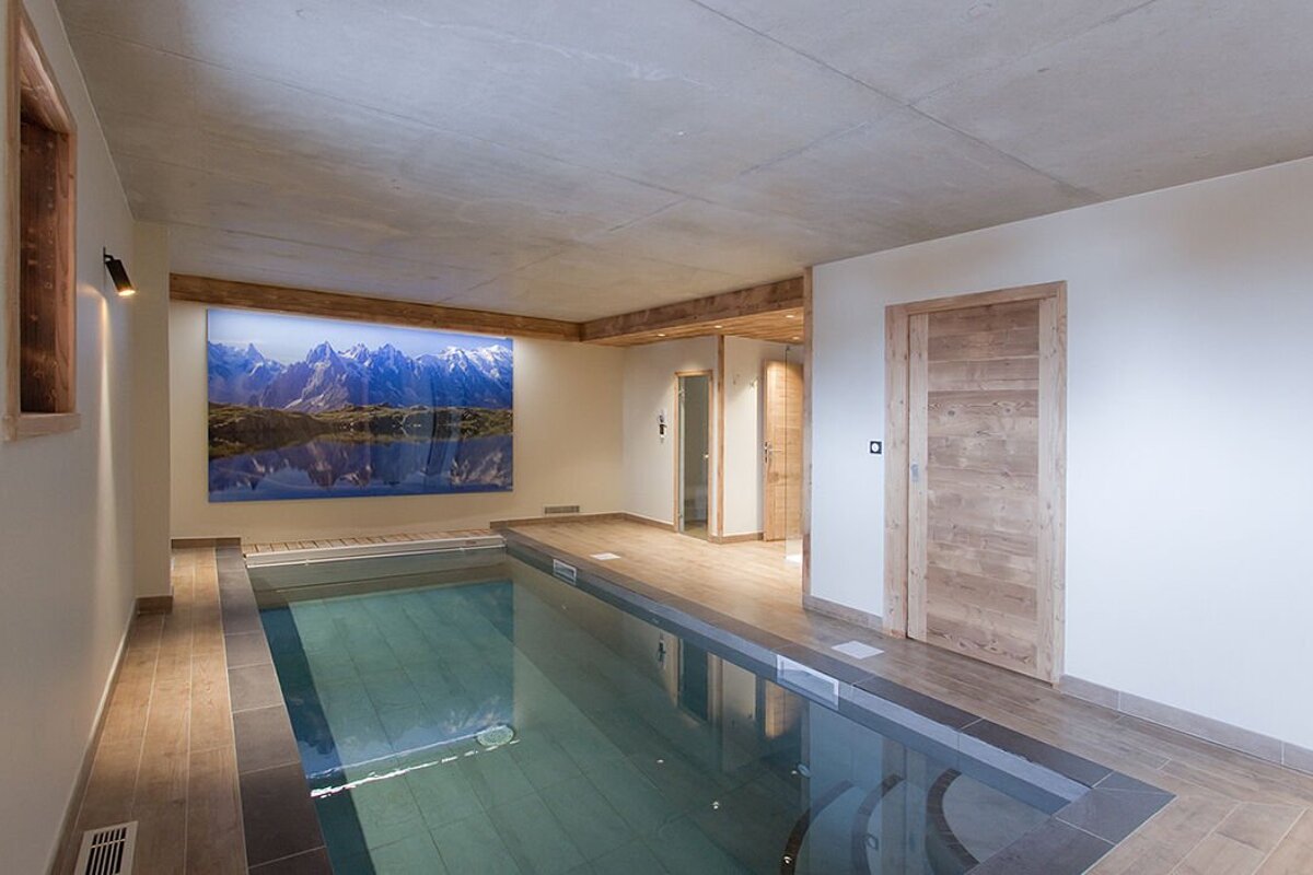 A large picture of mountains hangs above a swimming pool