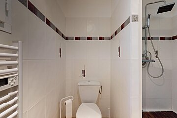 A bathroom with a toilet and a towel rack