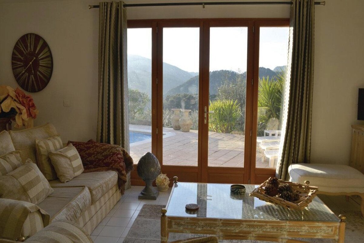 A living room with a couch and a clock on the wall