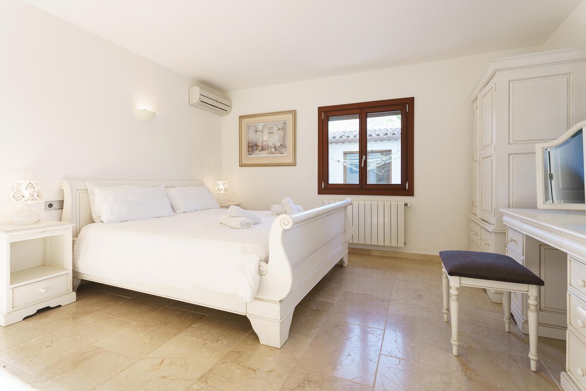 A bedroom with a sleigh bed and a picture on the wall