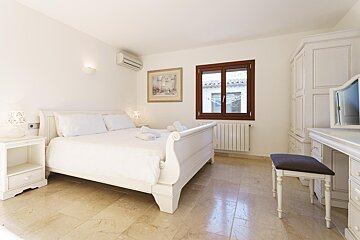 A bedroom with a sleigh bed and a picture on the wall