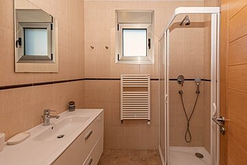 A bathroom with a sink and a walk in shower