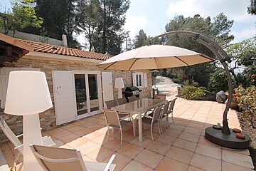 A patio with a table and chairs under an umbrella