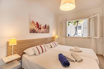 A bedroom with two beds and a painting on the wall