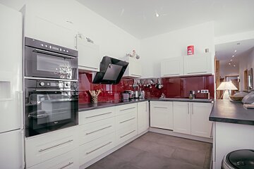 A kitchen with white cabinets and black appliances