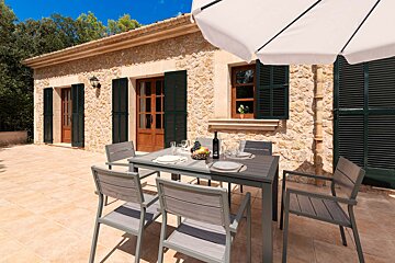 A patio with a table and chairs under an umbrella