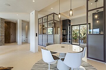 A dining room with a table and chairs and a sign that says skillphoto janssens