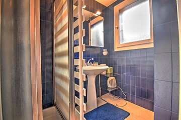 A bathroom with blue tiles and a white sink