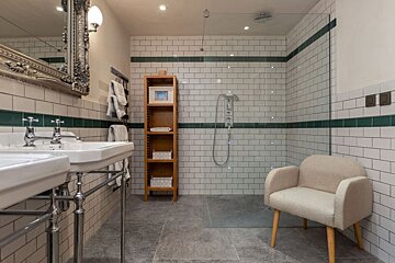 A bathroom with two sinks and a walk in shower