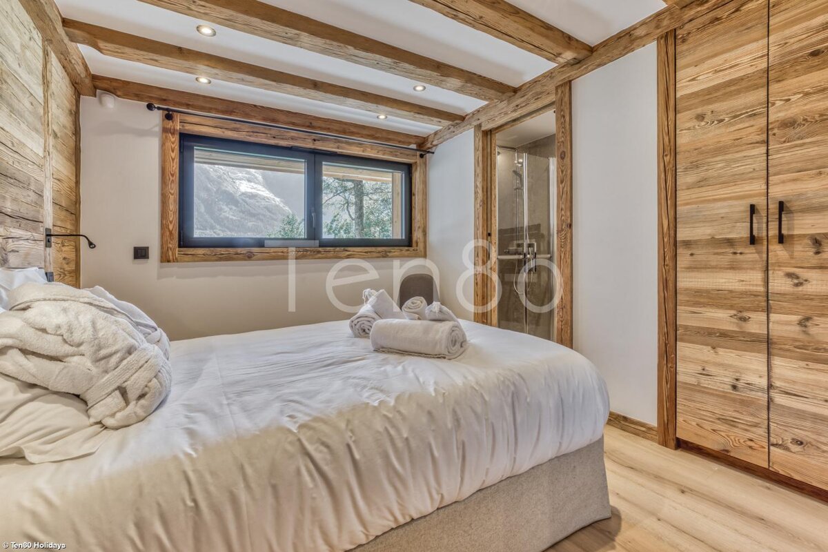 A bedroom with a bed and a window that says ten80