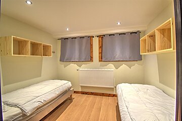 A bedroom with two beds and a radiator