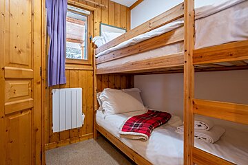 A bunk bed with a plaid blanket on it