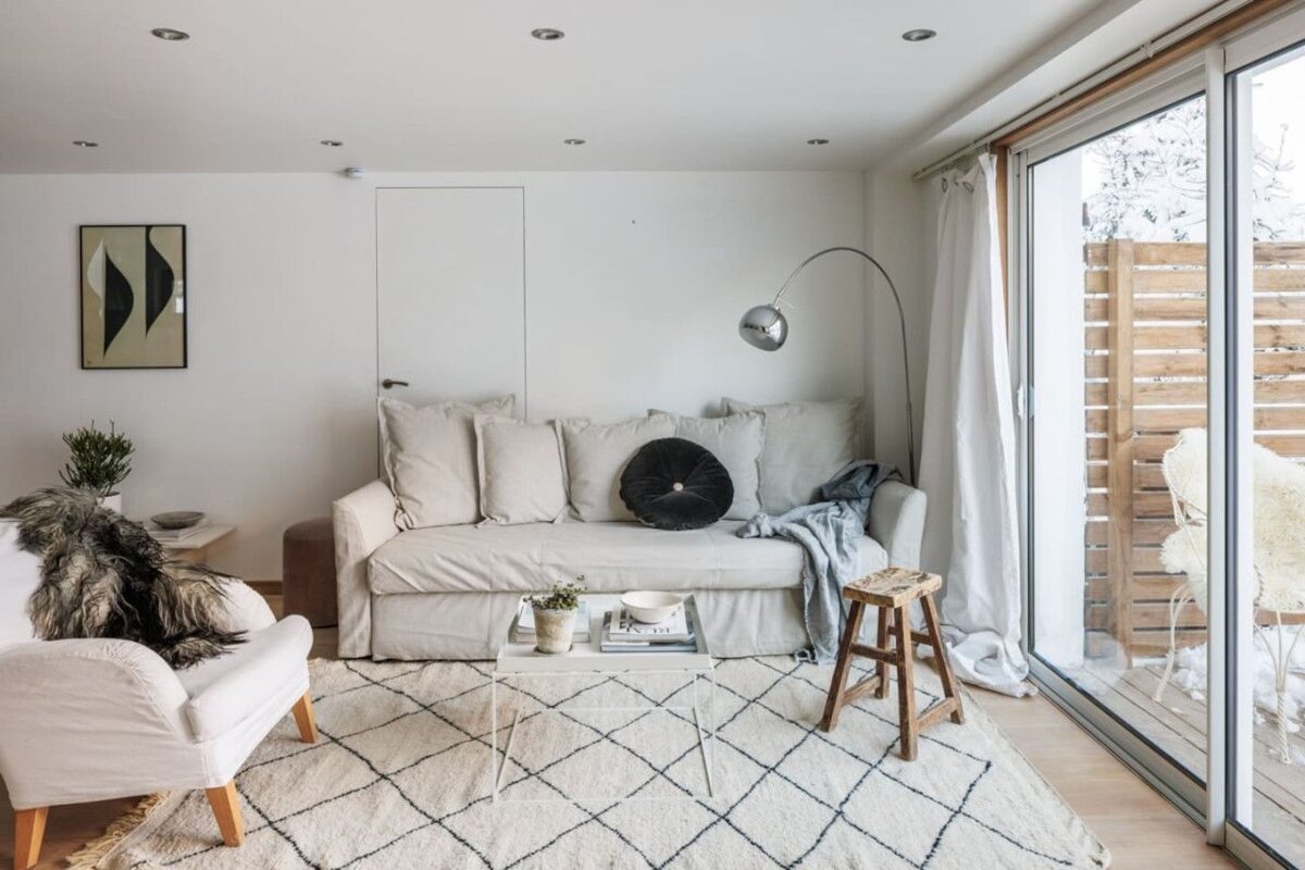 A living room with a couch a chair and a rug