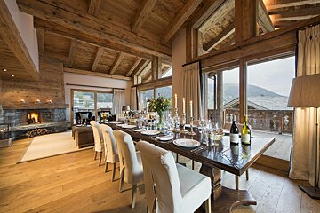 A dining room table with a bottle of wine on it