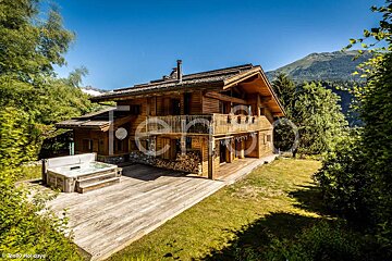 A large wooden house with a hot tub in front of it