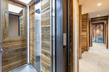 An elevator with wood paneling and a sign that says ' elevator ' on it
