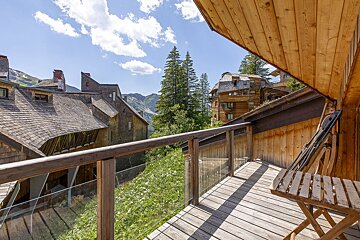 A balcony with a chair and a view of mountains