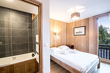 A bedroom with a bathtub and a picture on the wall that says