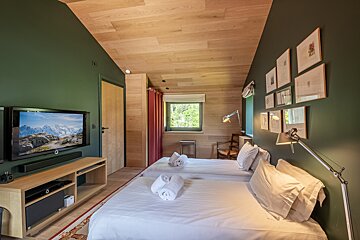 A bedroom with two beds and a flat screen tv