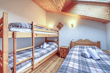 A bedroom with bunk beds and a single bed
