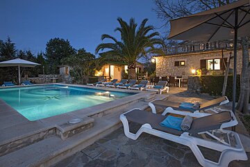 A large swimming pool is lit up at night