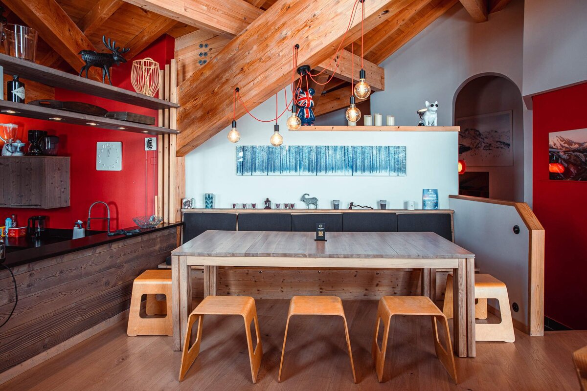 A kitchen with a wooden table and stools