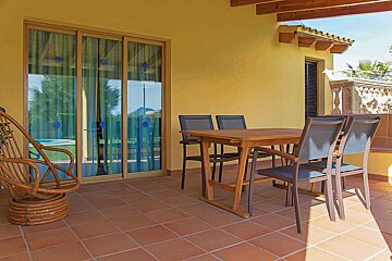 A patio with a table and chairs and a sliding glass door