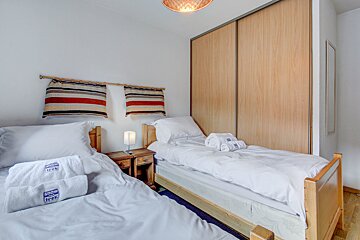 A bedroom with two beds and towels that say snow trek