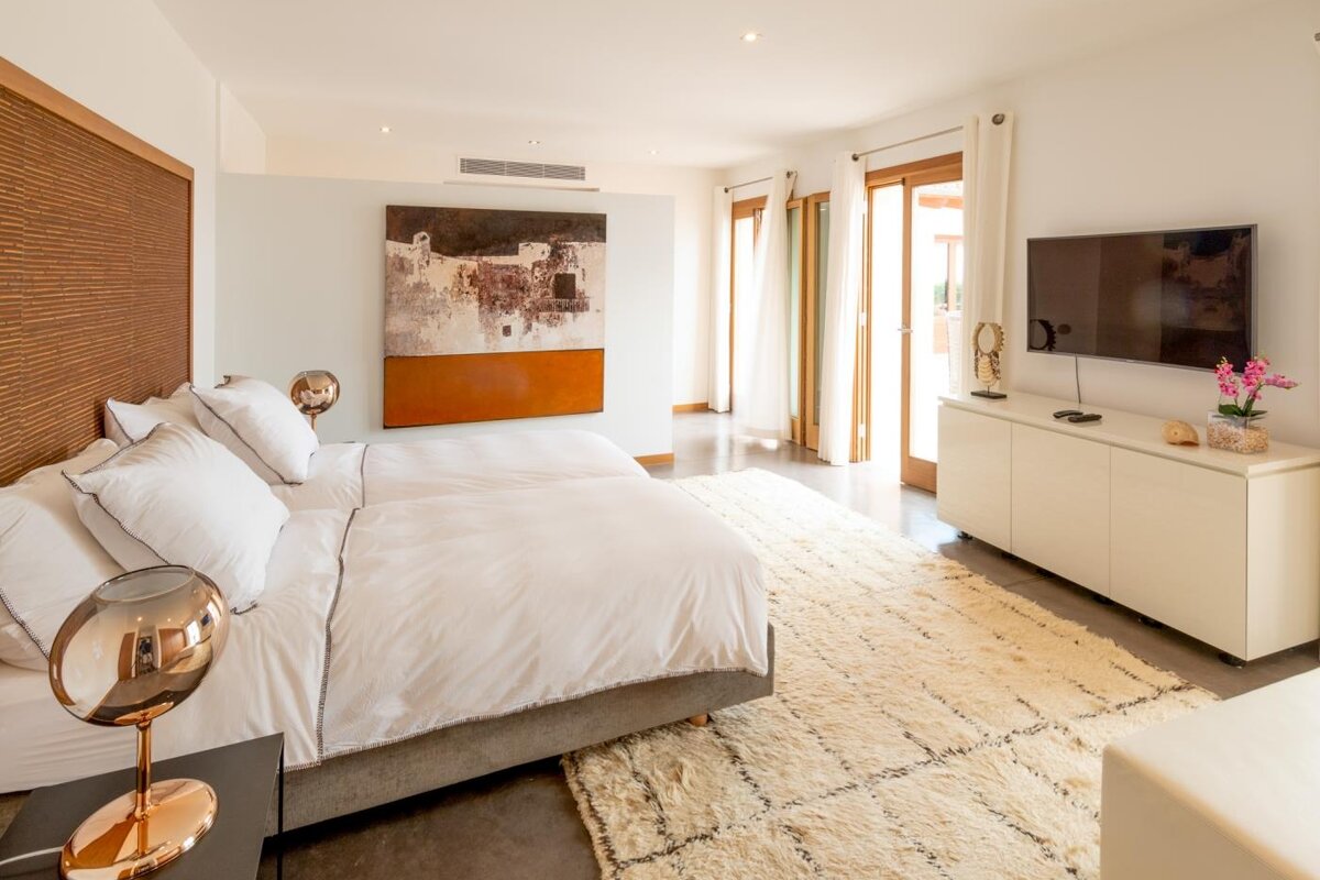 A bedroom with two beds and a flat screen tv